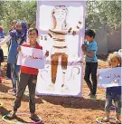  ??  ?? Inspiratio­n: Children hold up tributes to Dema Aktaa in thanks for her work to combat Covid-19 in migrant camps