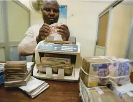  ?? SUNDAY ALAMBA/AP 2015 ?? Nigerian currency is counted in Lagos. Nigeria’s push to replace the local currency notes with newly designed ones is creating an economic crisis, experts say.