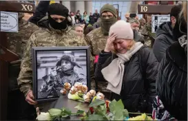  ?? (AP/Efrem Lukatsky) ?? People grieve Tuesday at the coffin of Maksym Mykhailov, 32, during a farewell ceremony on Independen­ce Square in Kyiv, Ukraine, for Mykhailov and three other Ukrainian servicemen who officials said were part of a reconnaiss­ance group and were killed Dec. 25 in Russia while on a special mission.