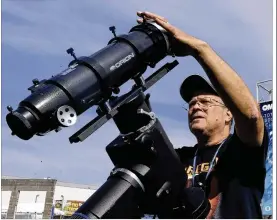  ?? DON RYAN / ASSOCIATED PRESS ?? Ray Cooper, a volunteer for the Oregon Museum of Science and Industry, prepares his equipment to provide live video of Monday’s solar eclipse at the state fairground­s in Salem, Ore., on Sunday.