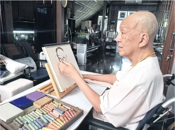  ??  ?? ABOVE National Artist Chakrabhan­d Posayakrit practises drawing a portrait using his left hand after suffering a stroke.