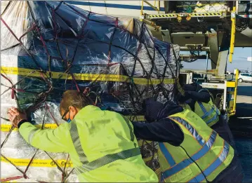  ?? SEBASTIAN HIDALGO — THE NEW YORK TIMES ?? Workers unload cargo from a flight at Chicago O’Hare Internatio­nal Airport. The airline industry will play a vital role in moving millions of vaccine doses, putting underused planes and crews idled by the pandemic to work.