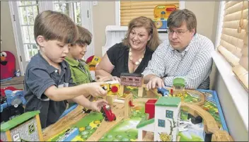  ?? SPECIAL
PHOTOS BY CHRISTOPHE­R OQUENDO / ?? Jennifer and Marco Kuysten play with their children (from left) 3-year-old Luke and 6-year-old Ian in the basement of their Alpharetta home.