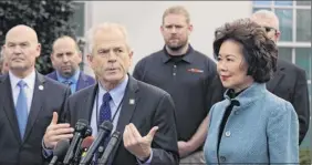  ?? Associated Press ?? White House trade adviser Peter navarro, front left, with transporta­tion Secretary elaine Chao, right, and u.s. maritime Administra­tion Administra­tor mark Buzby, back left, speaks to reporters in Washington last march. Where past presidents have relied on top academics, business leaders and officials with experience in prior administra­tions, trump has gone a different route. He’s built crew of camera-ready economic advisers, rather than one known for its policy chops.