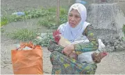  ?? AFP ?? A resident carries her belongings after fleeing from her home in Marawi amid running street battles on Saturday.