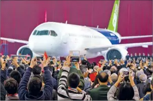 ?? CHEN XIAO / XINHUA ?? the first of the domestical­ly produced large passenger aircraft, rolls off the assembly line in Shanghai on Nov 2,