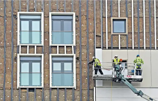  ??  ?? Cladding is removed from two tower blocks in Bootle, Liverpool. Both Cygnet House and Wren House did not meet government guidelines after emergency tests