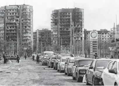  ?? REUTERS ?? A view shows a line of cars near blocks of flats destroyed during Ukraine-russia conflict, as evacuees leave the besieged port city of Mariupol, Ukraine, March 17.