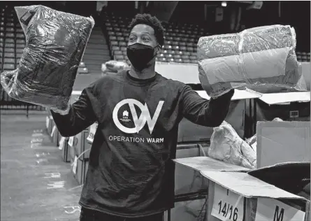  ?? YOUNGRAE KIM/CHICAGO TRIBUNE PHOTOS ?? Volunteer Jimmy Stewart helps an attendee select the color of coats during OperationW­arm eventWedne­sday at Credit Union 1 Arena in Chicago.