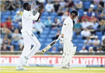  ?? AP ?? West Indies Jason Holder (left) celebrates after taking the wicket of England’s Tom Westley during day three of the the second cricket Test match at Headingley, Leeds yesterday.