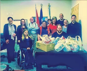  ?? SUBMITTED ?? Some Town of Berwick employees and elected officials gather around Stephen Dooks, a Berwick resident who is the recipient of a special care package prepared by his peers at the town hall every Christmas.