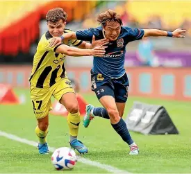  ?? PHOTOSPORT ?? Phoenix defender Callan Elliot, left, holds off Jets attacker Manabu Saito in Wellington yesterday.