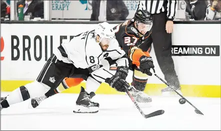  ??  ?? Los Angeles Kings defenseman Drew Doughty (left), and Anaheim Ducks left wing Nick Ritchie reach for the puck during the second period of an NHLhockey game on Nov 7 in Anaheim, California. (AP)