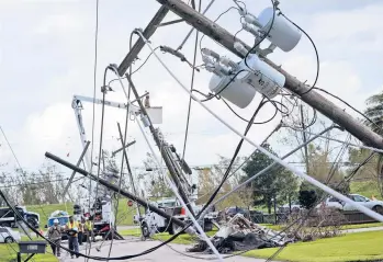  ?? STEVE HELBER/AP ?? Crews begin work on downed power lines leading to a fire station Tuesday in Waggaman, La., as residents try to recover from the effects of Hurricane Ida. New Orleans Mayor LaToya Cantrell encouraged residents to begin returning home.