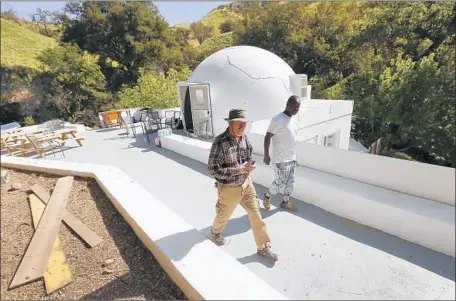  ?? Photograph­s by Al Seib Los Angeles Times ?? FILMMAKER George Szabo and activist Abiyah Jujumane visit a prototype for a domed housing unit at Wayne Fishback’s property.