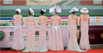  ?? AFP ?? Models pose for photos during yesterday’s Internatio­nal Horse Racing Festival in Wuhan in China's central Hubei province, where the Covid-19 epidemic first surfaced a year ago.