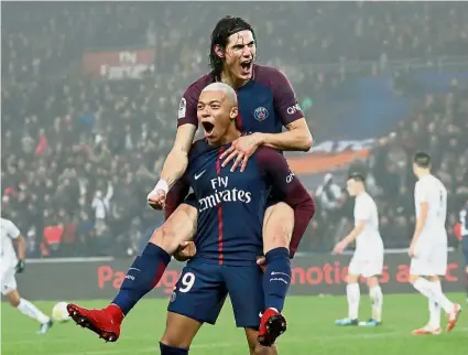  ??  ?? Memorable present: Paris St Germain’s Kylian Mbappe celebratin­g with Edinson Cavani after scoring against Caen on Wednesday.