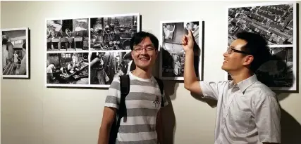  ??  ?? Shanghai resident Ruan Wenjun (left) and his cousin poses with the photo depicting his former home at a local exhibition to commemorat­e the 40th anniversar­y of China’s reform and opening up to the outside world. — Ti Gong