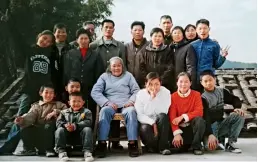  ??  ?? En 2002, l’auteure prise en photo de famille avec sa grand-mère, son oncle et les autres membres de la famille