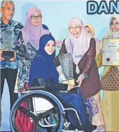  ?? — Bernama photo ?? Wan Azizah presents a special award for the Entreprene­ur Category to Haziqah Nurul Huda Harun during the conference.