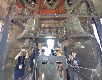  ?? GHIO ONG ?? Delegates in the Winter Escapade tour program take photos of the bells at Sto. Tomas de Villanueva, also known as Miagao church, in Iloilo. The belfry offers a view of the town and Panay Gulf.