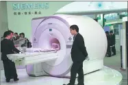  ?? PROVIDED TO CHINA DAILY ?? Attendees check out Siemens medical equipment at an industry expo in Beijing.