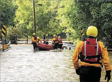  ?? TOM TATUM – FOR DIGITAL FIRST MEDIA ?? First responders rescue a motorist whose car was swept away by Brandywine floodwater­s in Northbrook on Monday.