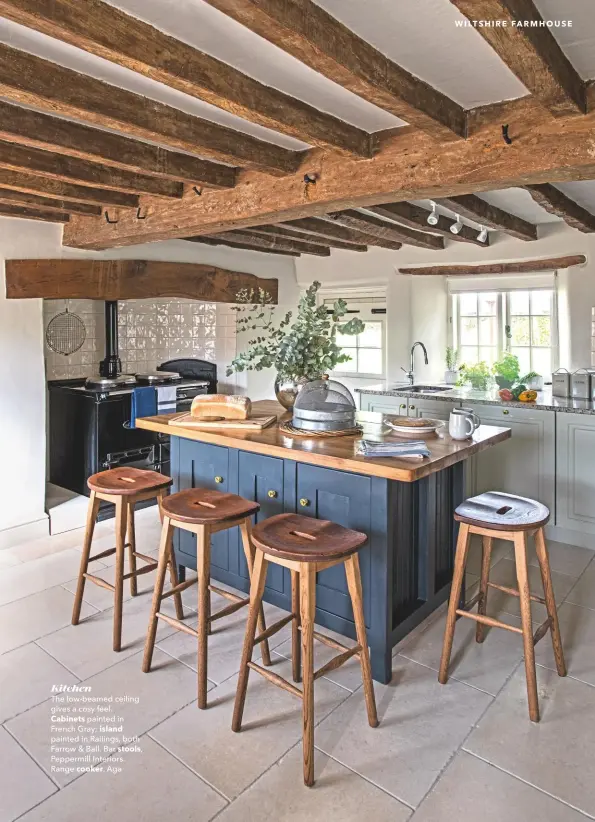  ??  ?? Kitchen
The low-beamed ceiling gives a cosy feel.
Cabinets painted in French Gray; island painted in Railings, both Farrow & Ball. Bar stools, Peppermill Interiors. Range cooker, Aga
