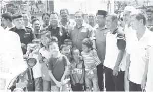  ??  ?? MIJUL (tengah) bersama Douglas dan para pemimpin bergambar dengan penduduk kampung selepas majlis itu.