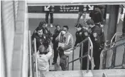  ?? HIROKO MASUIKE The New York Times ?? Ameed Ademolu, center, a nurse working with NYPD officers, speaks with a man at the Fulton Street subway station in Manhattan. Medical workers and police are removing people in psychiatri­c distress from the transit system.