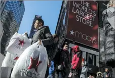  ?? BEBETO MATTHEWS — THE ASSOCIATED PRESS ?? A shopper leaves Macy’s department store during Black Friday shopping in New York last year. Macy’s reported stronger-thanexpect­ed sales and profits for the fourth quarter.