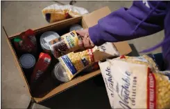  ?? ?? Stephanie Garcia of San Jose shows the food donations she received Friday.