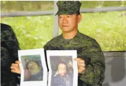  ?? Associated Press ?? Army Chief of Staff Gen. Eduardo Año holds photos of dead militant leaders in Marawi.