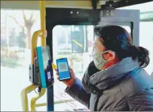  ?? ZHANG LONG / XINHUA ?? A woman pays for a bus journey via a QR code in Xi’an, capital of Shaanxi province.