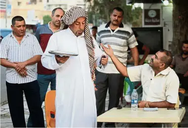  ??  ?? Serving up sarky truths: An Iraqi man performing a theatrical skit on the Corniche Street in the southern city of Kut. — AFP