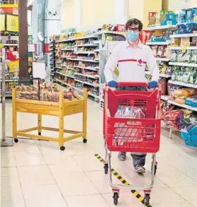  ?? FOTO: EFE ?? Supermerca­do en Palma de Mallorca. Un voluntario de la Cruz Roja haciendo la compra