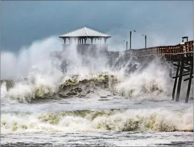  ?? TRAVIS LONG/THE NEWS & OBSERVER VIA AP ?? Waves slam the Oceana Pier &amp; Pier House Restaurant in Atlantic Beach, N.C., on Thursday as Hurricane Florence approaches the area.