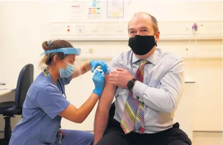  ??  ?? Vital role: Dr Michael Mcbride receives the Oxford/ Astrazenec­a vaccine from Nurse Alana Mccaffery