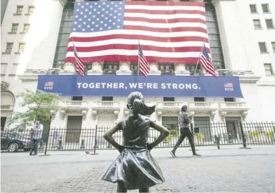  ?? (Photo: AP) ?? The Fearless Girl statue stands in front of the New York Stock Exchange in New York. US stocks edged lower in early trading yesterday as investors worried that rising virus cases will delay a full economic recovery while the world waits for wide distributi­on of a vaccine.