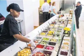  ?? [PHOTO BY CHRIS LANDSBERGE­R, THE OKLAHOMAN] ?? Alishia Pearson works behind the counter at the Coolgreens at Will Rogers World Airport.