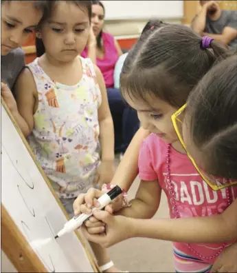  ??  ?? Diana helping her sister Daniela with letter C during Memorial Library. PHOTO COURTESY OF LIZETH LEGASPI storytime at Camarena