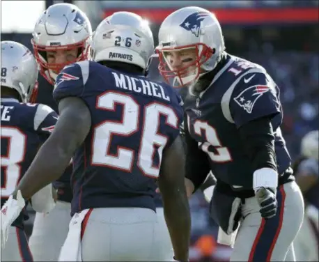  ?? ELISE AMENDOLA — THE ASSOCIATED PRESS ?? Patriots quarterbac­k Tom Brady, right, celebrates a touchdown run by running back Sony Michel during the first half of an NFL divisional playoff football game against the Los Angeles Chargers, Sunday in Foxborough, Mass.