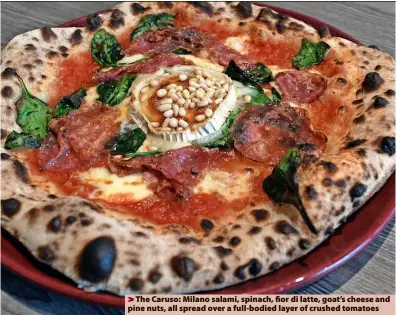  ?? ?? > The Caruso: Milano salami, spinach, fior di latte, goat’s cheese and pine nuts, all spread over a full-bodied layer of crushed tomatoes