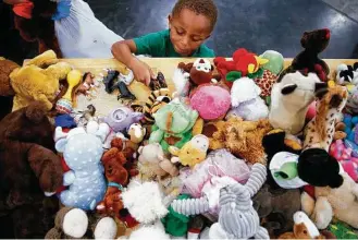  ?? Michael Ciaglo / Houston Chronicle ?? Jacob Evans, 4, picks out a toy from a donations table at the George R. Brown Convention Center where nearly 10,000 people are taking shelter after Hurricane Harvey.