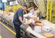  ?? NATI HARNIK/ASSOCIATED PRESS ?? Steve Robino arranges packages on a conveyor belt at the main post office in Omaha, Neb. The shipment of several pipe bombs to CNN and others raise fresh questions about mail safety.