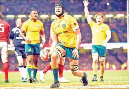  ?? PAUL ELLIS/AFP ?? Australia lock Adam Coleman (centre) celebrates after scoring a try during their Test with Wales on Saturday at the Principali­ty Stadium in Cardiff, South Wales.