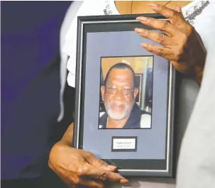  ?? STAFF PHOTO BY ERIN O. SMITH ?? Linda Bonner holds on to a photo of her late husband, Franklin Augustus “Kookie” Bonner, during a news conference at the Newell Towers on Tuesday. On Wednesday, authoritie­s arrested Mallory Vaughn and charged him with the 2009 slaying of Franklin Bonner.