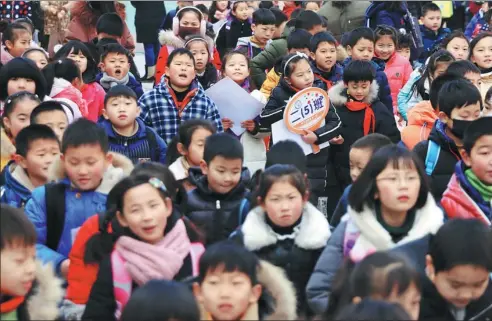  ?? ZHOU GUKAI / FOR CHINA DAILY ?? Primary-level students from Yancheng, Jiangsu province, prepare to leave school for the winter holiday.