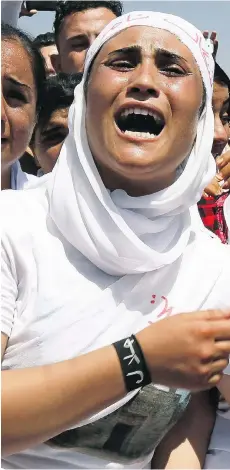  ?? SEIVAN M.SALIM / THE ASSOCIATED PRESS ?? A Guatemalan immigrant, left, in the U.S. arrives for a deportatio­n flight out of Texas. A Yazidi woman, right, protests against the Islamic State. On a day that the U.S. announced it was strengthen­ing immigratio­n enforcemen­t, Canada said asylum would...