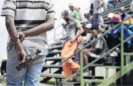  ?? / PHOTOS/TIRO RAMATLHATS­E ?? A resident with a petrol bomb during a meeting at Tshing. Residents are unhappy about their newly merged municipali­ty.